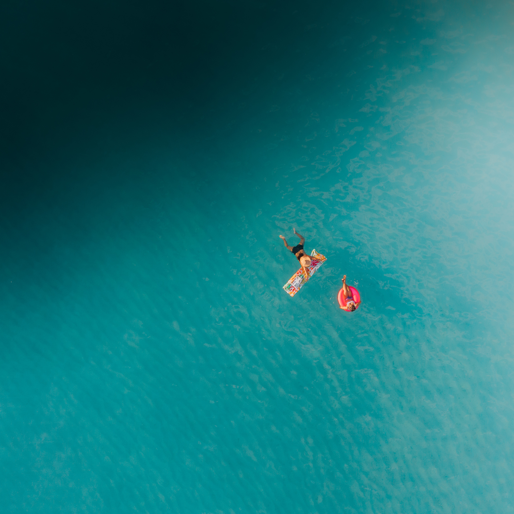 2 Person in Red and White Wetsuit Surfing on Blue Water